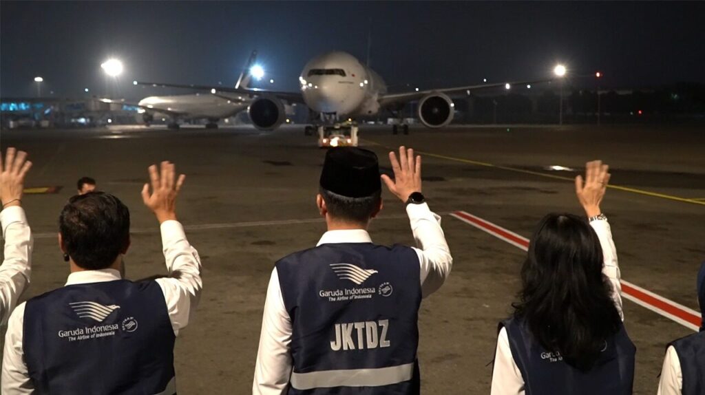 Foto: Petugas Garuda Indonesia melambaikan tangan sebagai bentuk penghormatan dan doa keselamatan bagi jemaah haji yang siap diberangkatkan menuju Tanah Suci.